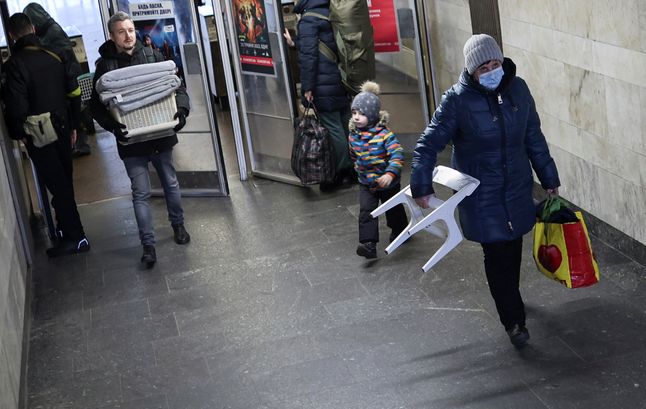 Mieszkańcy opuszczają schron na stacji metra w Kijowie.