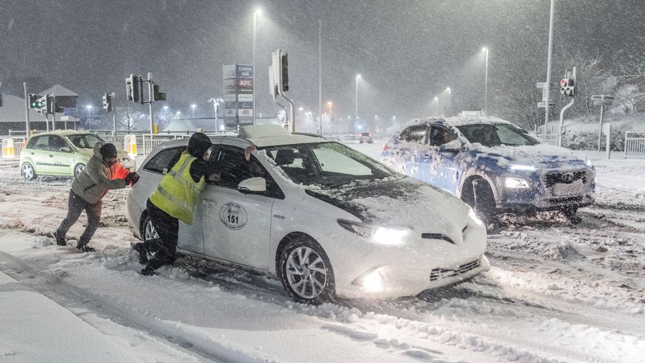 People help to push cars stuck in snow in Leeds, Yorkshire. Heavy overnight snow is causing disruption across the UK as the cold start to the new year continues. Picture date: Sunday January 5, 2025. (Photo by Danny Lawson/PA Images via Getty Images)
