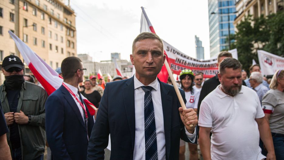 WARSAW, MAZOWIECKIE, POLAND - 2022/08/01: Robert Bakiewicz, leader of the Independence March Association, walks with a Polish flag during the march in Warsaw. Thousands of people participated in a march organized by nationalist organizations to celebrate the 75th anniversary of the Warsaw Uprising. The Warsaw Uprising (Powstanie Warszawskie) was the largest military operation by any European resistance movement against the Nazi German occupiers during World War II. (Photo by Attila Husejnow/SOPA Images/LightRocket via Getty Images)