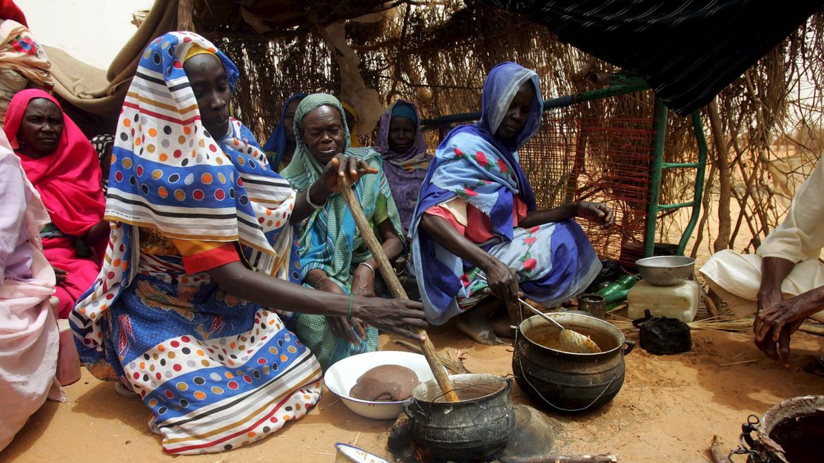 Uchodźcy z ogarniętego wojną domową Darfuru w Sudanie gotują pos