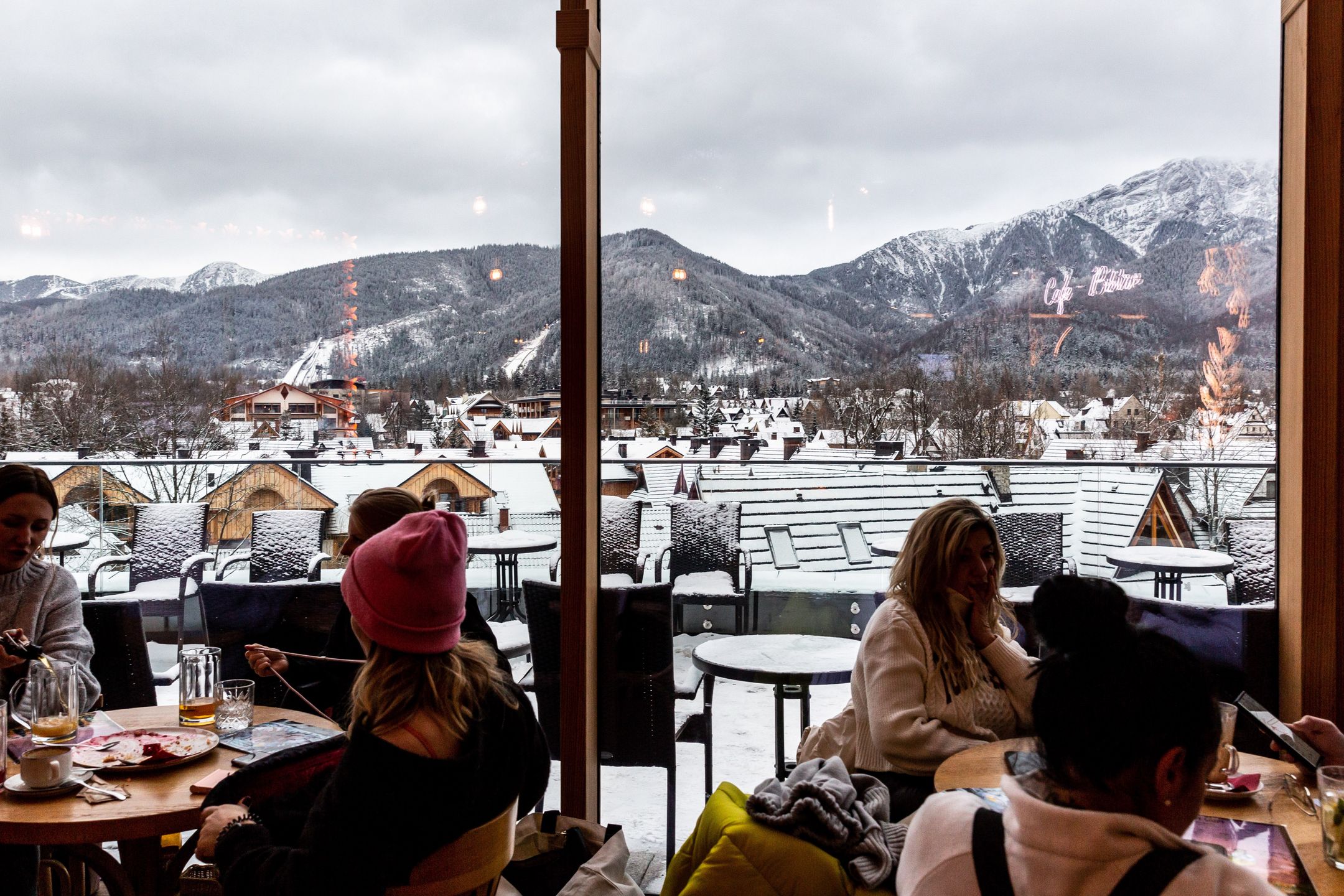 ZAKOPANE, MALOPOLSKIE, POLAND - 2024/01/19: Families sit in a cafe with a view of the mountain range along Krupowki Street in the center of Zakopane, a popular Tatra mountain holiday resort. (Photo by Dominika Zarzycka/SOPA Images/LightRocket via Getty Images)