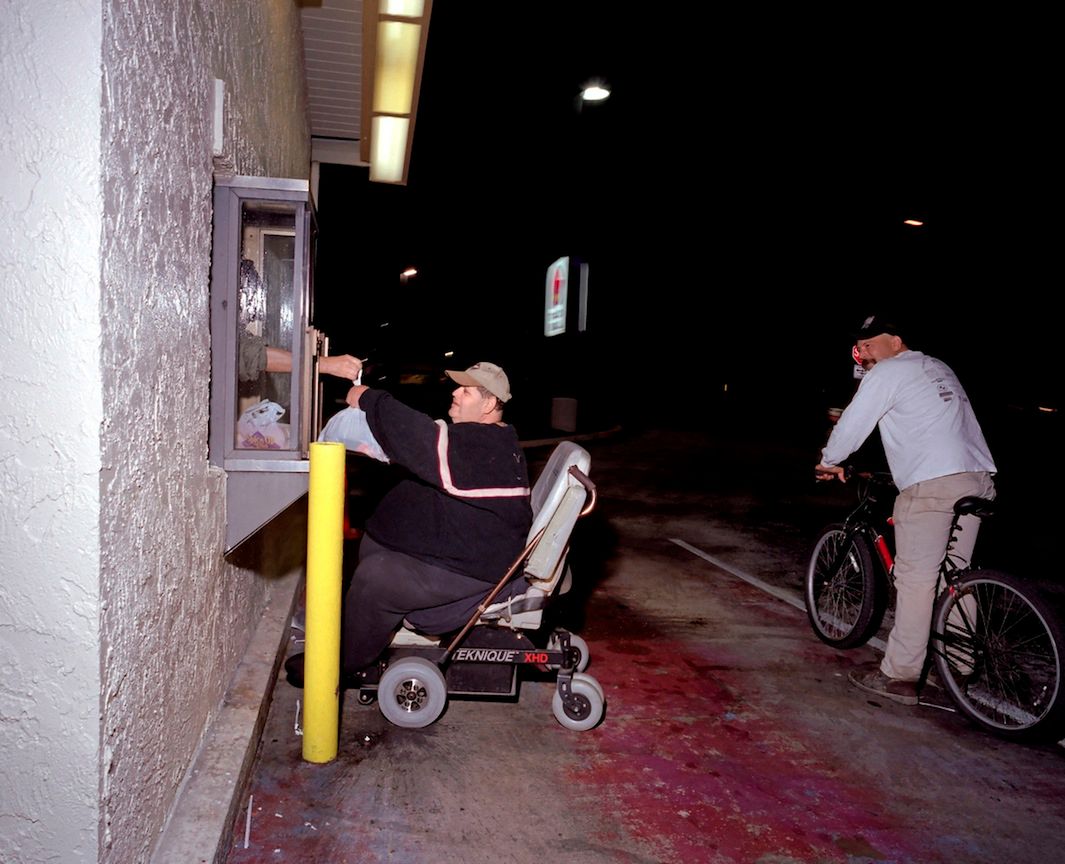 Mężczyzna na elektrycznym wózku odbiera zamówienie z Taco Bell drive-thru, pytając się sprzedawcy: "Na pewno czegoś takiego jeszcze nie widziałeś?". Floryda, 2006