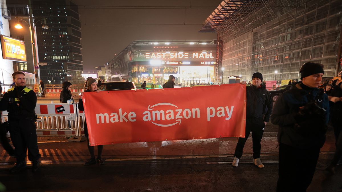 Demonstrators hold up a 'Make Amazon Pay' banner during a demonstration supporting Amazon.com workers, on a day of global strike action by the company's employees, on Black Friday in Berlin, Germany, on Wednesday, Nov. 25, 2022. Amazon employees in the US, UK, India, Japan, Australia, South Africa and across Europe are demanding better wages and working conditions as the cost-of-living crisis deepens, in a campaign dubbed "Make Amazon Pay." Photographer: Krisztian Bocsi/Bloomberg via Getty Images
