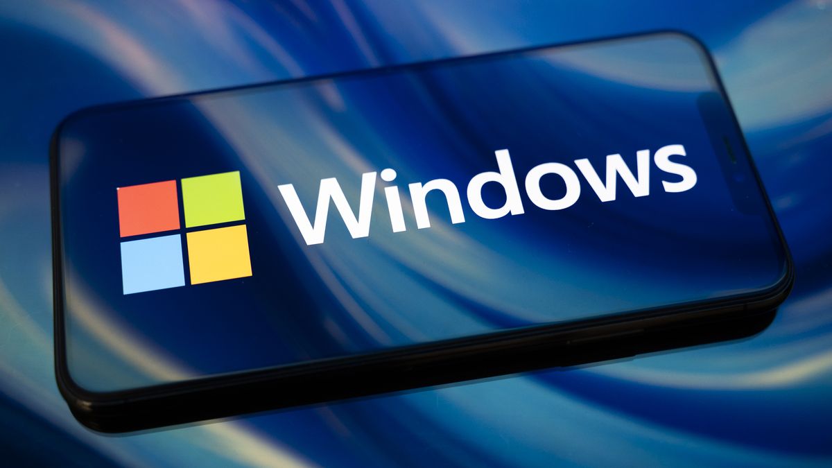 The Windows logo appears on the screen of a smartphone reflecting an abstract illustration in blue colors. Microsoft releases a major update to Windows 11 (25H2) and Windows 10 support ends permanently on October 14. In Creteil, France, on October 9, 2025. (Photo by Samuel Boivin/NurPhoto via Getty Images)