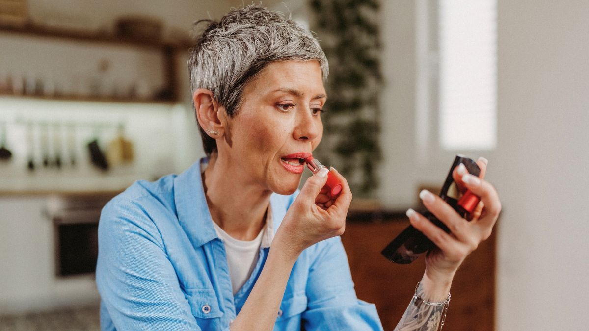Kobieta maluje usta szminką