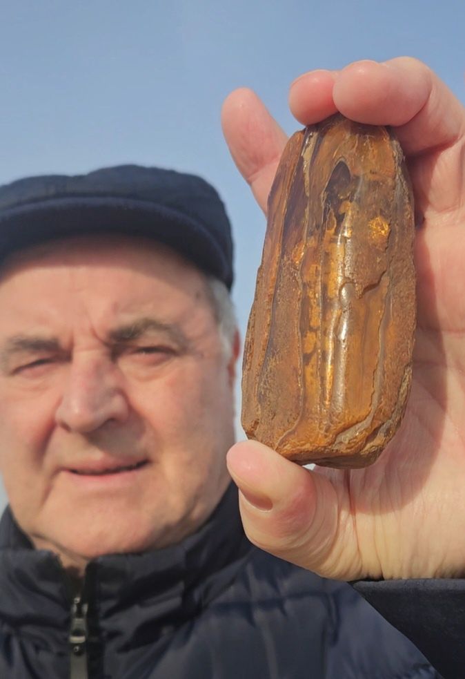 Sylwestrem Malucha prezentuje jeden ze swoich okazów bursztynu