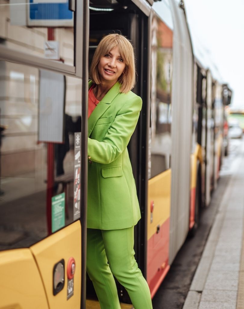 Grażyna Wolszczak "zaprzyjaźnia się"z komunikacją miejską, pozując na tle autobusu