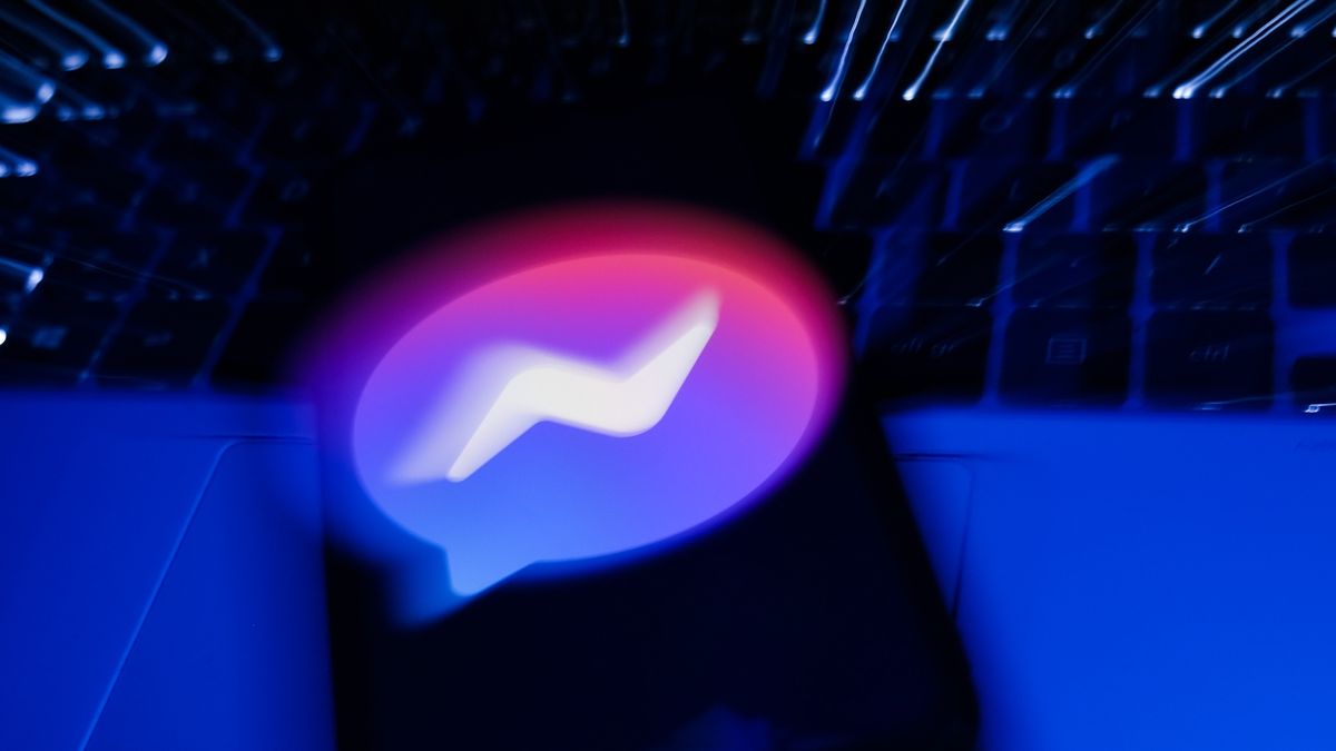 Messenger logo displayed on a phone screen and a laptop keyboard are seen in this long exposure illustration photo taken in Krakow, Poland on February 6, 2022. (Photo illustration by Jakub Porzycki/NurPhoto via Getty Images)