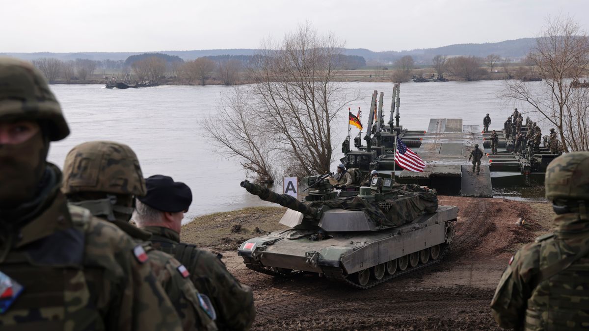 GNIEW, POLAND - MARCH 04: Polish soldiers stand by as a M1 Abrams main battle tank of the U.S. Army descends from M3 amphibious rigs of the German/British Amphibious Engineer Battalion 130 after crossing the Vistula River during the NATO Dragon 24 military exercise on March 04, 2024 near Gniew, Poland. Dragon 24 is involving 20,000 troops from 10 different nations and is part of Steadfast Defender 2024, an ongoing set of NATO military manoeuvres across Europe that is involving 90,000 troops. (Photo by Sean Gallup/Getty Images)
