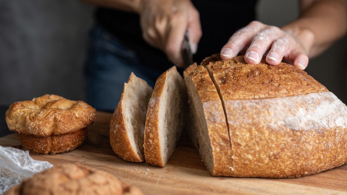 Mężczyzna krojący bochenek chleba