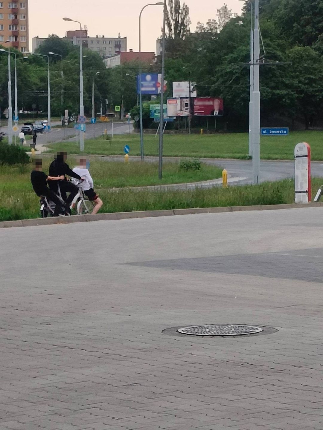 Trzech nastolatków jadących na jednym rowerze miejskim