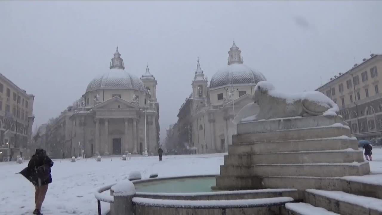 Koloseum i fontanna Di Trevi w zimowej aurze. Rzym zasypany śniegiem, szkoły zamknięte