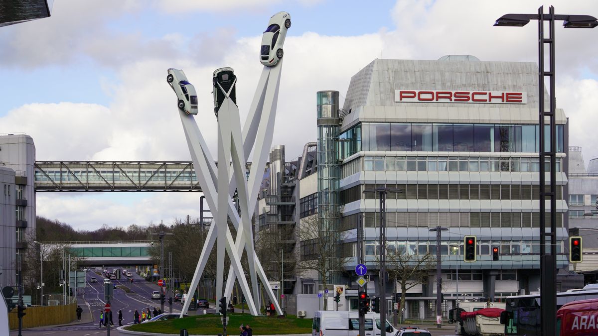 In Stuttgart, Zuffenhausen, Baden-Wuerttemberg, Germany, on March 11, 2023, the Porsche headquarters building stands alongside the Porsche monument featuring three iconic cars mounted on tall, white pillars. The area serves as a central landmark symbolizing the brand's heritage and innovative design. (Photo by Michael Nguyen/NurPhoto via Getty Images)