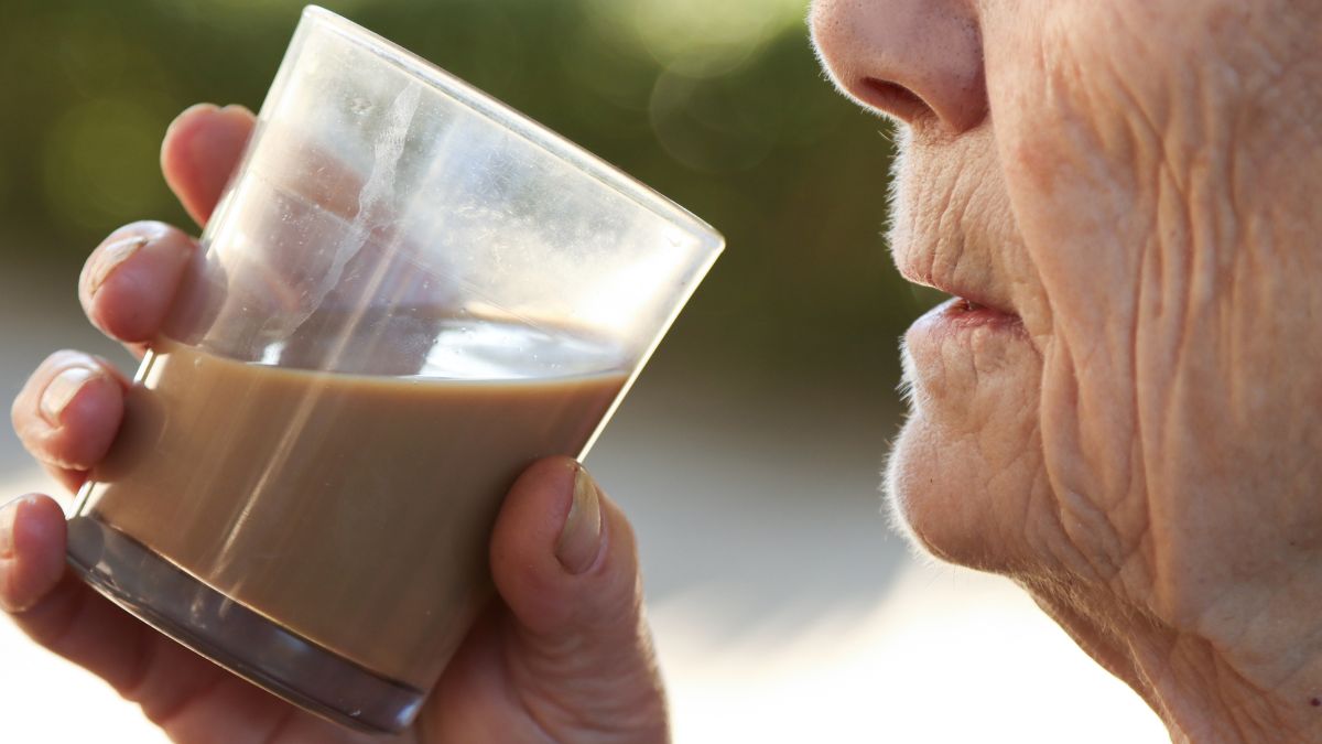 Starsza osoba pije kawę