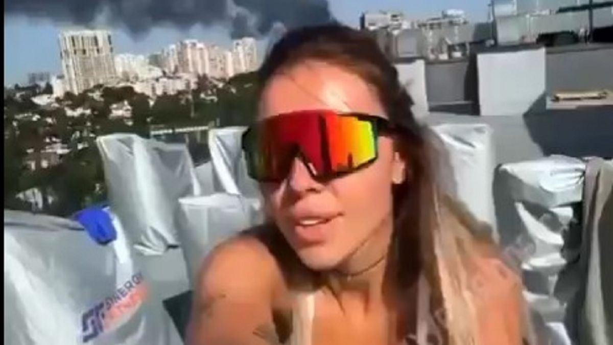 Ukrainka ćwiczy aerobik. W tle dym po rosyjskich atakach.