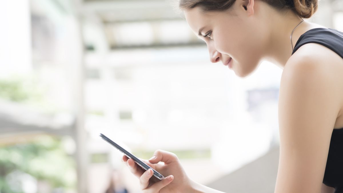 Młoda kobieta ze smartfonem. Bankowość mobilna