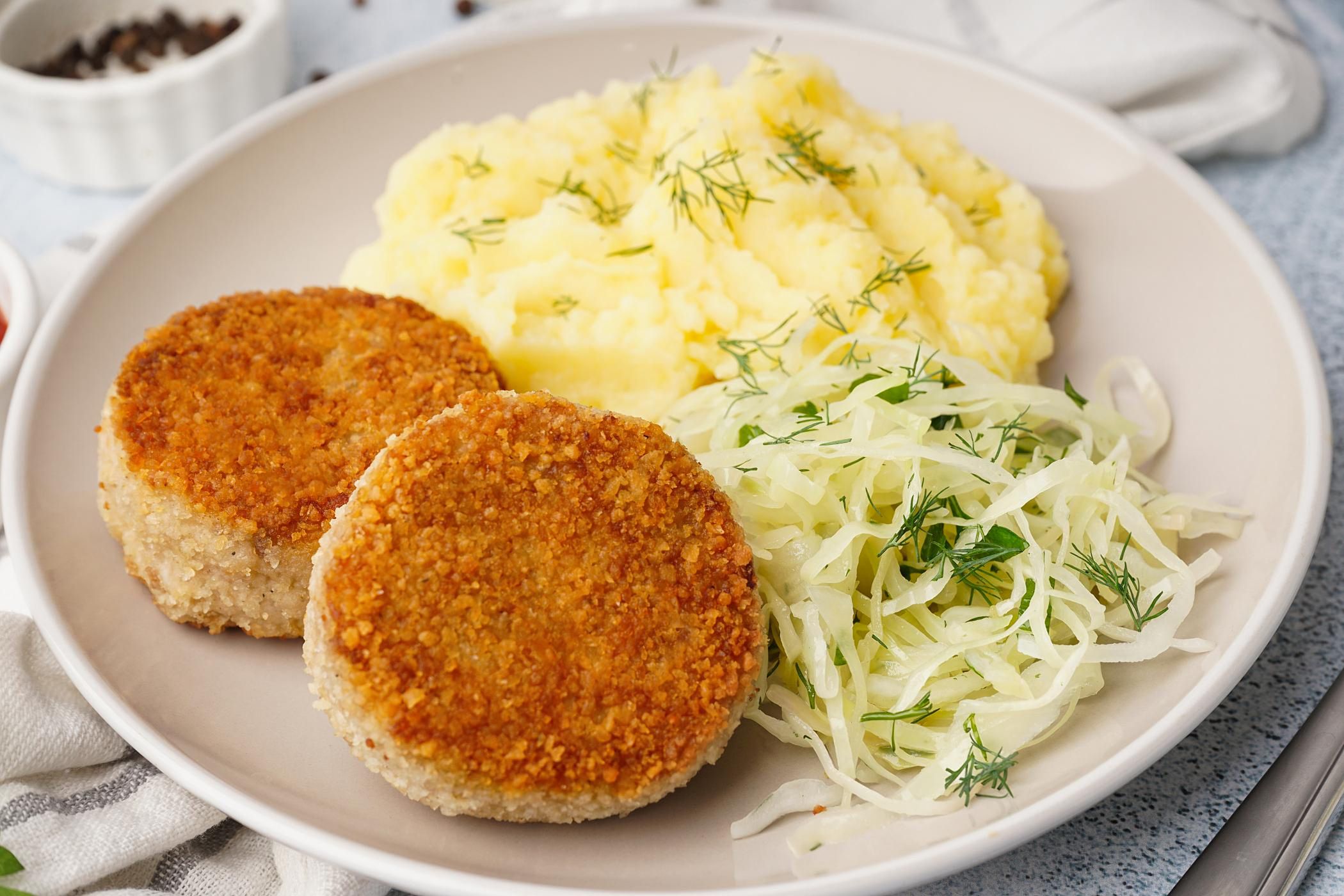 Kotlet mielony z ziemniakami i surówką na talerzu