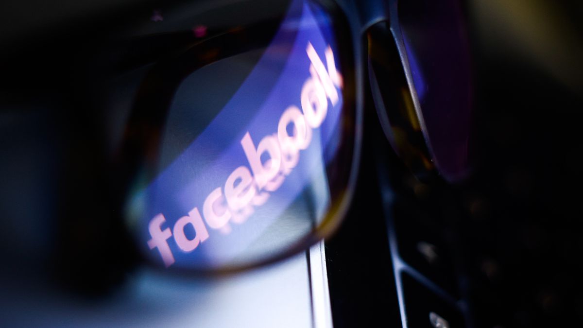 The Facebook logo is seen reflected in a pair of glasses on a computer keyboard in this photo illustration in Warsaw, Poland on March 4, 2021. As part of its policy on COVID-19-related misinformation, Facebook will start removing posts with false claims about vaccines. (Photo by Jaap Arriens/NurPhoto via Getty Images)
