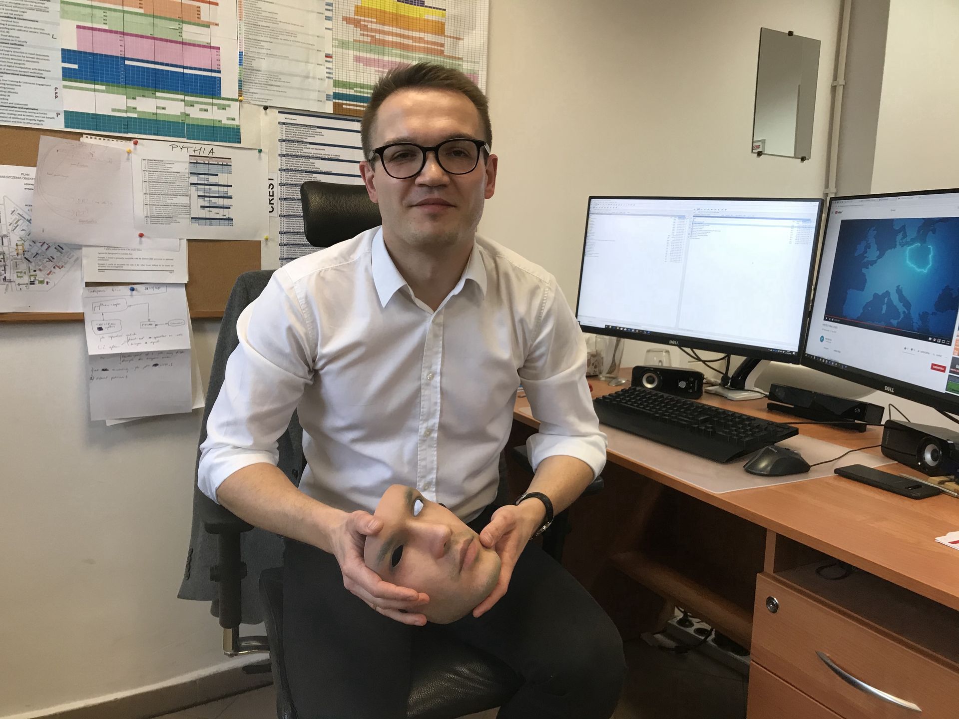 Dr Marcin Kowalski z Wojskowej Akademii Technicznej z maską przedstawiającą jego wizerunek.