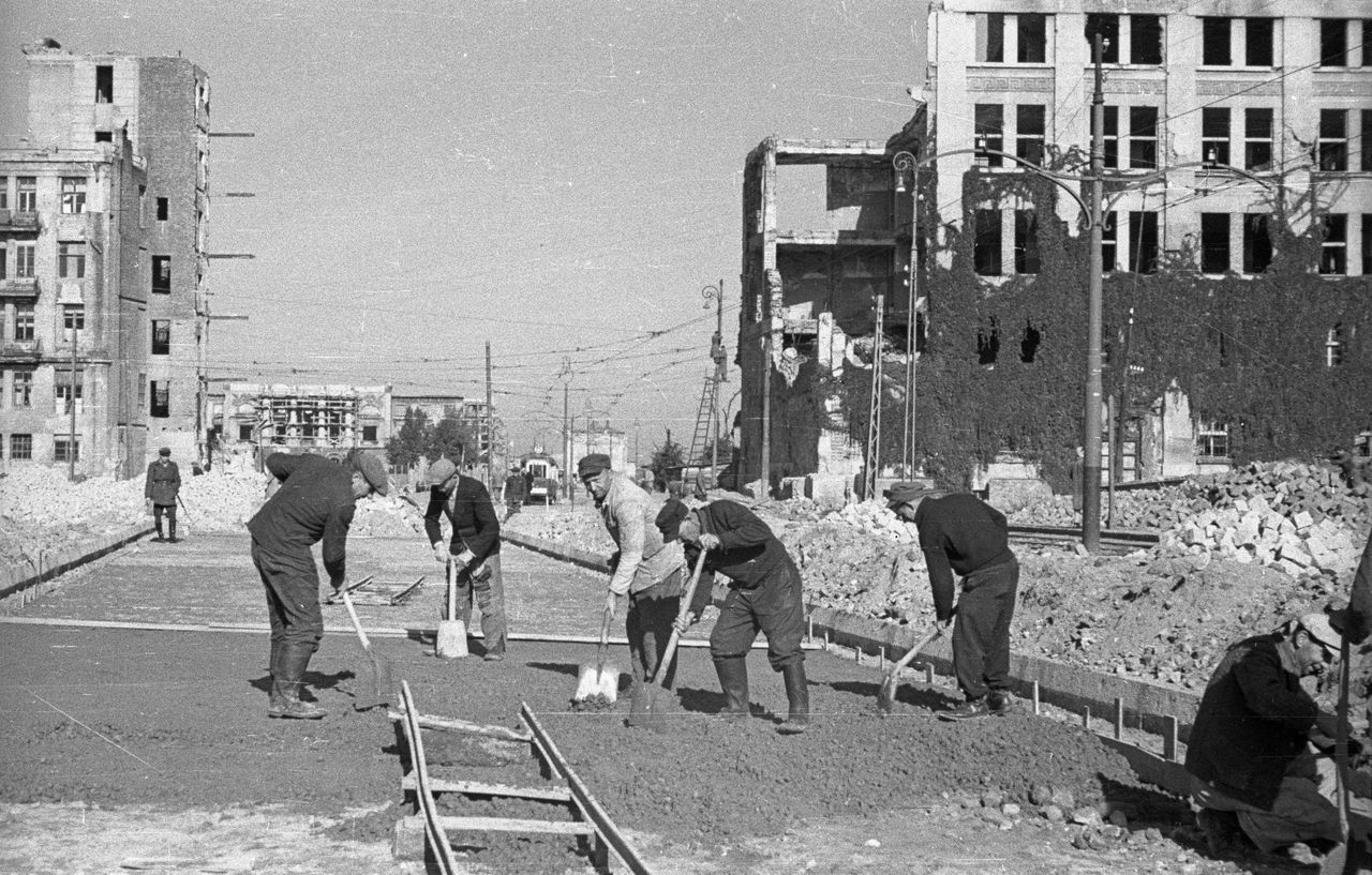 Warszawa. Budowa nowej ulicy Marszałkowskiej. Prace na placu Bankowym. Budowa jezdni. W tle ruiny pałacu Mostowskich