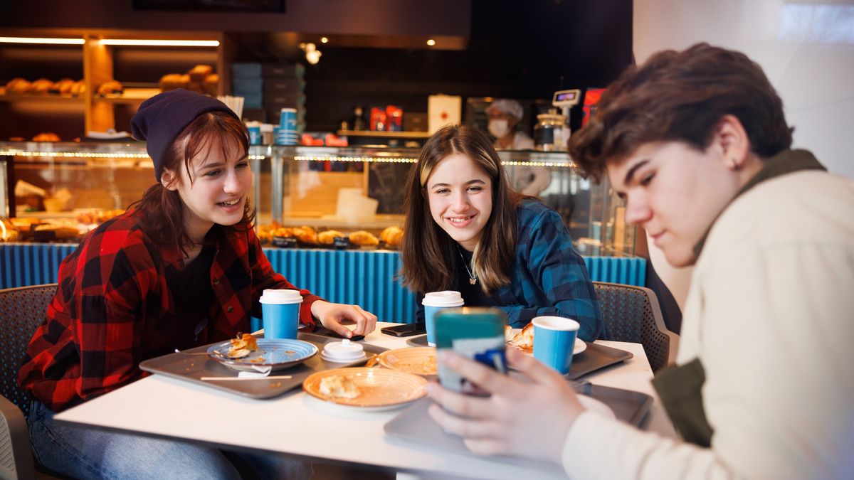 Młodzi ludzie w restauracji przy telefonie