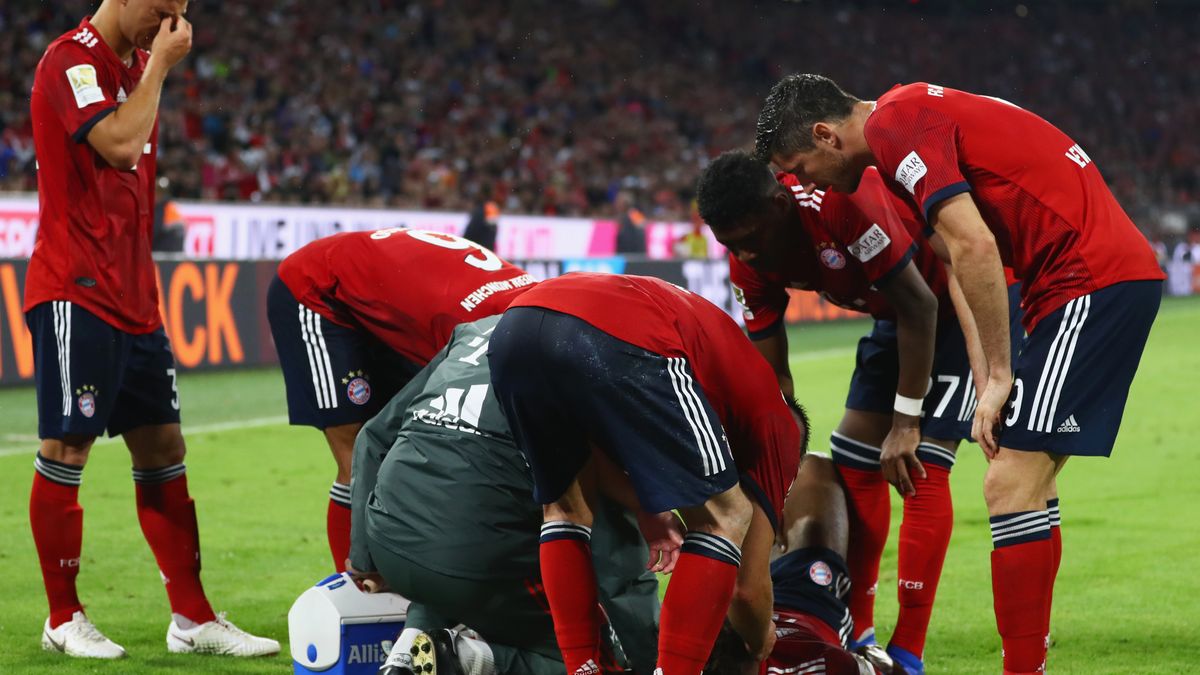 Kingsley Coman zwijał się z bólu, a piłkarze Bayernu próbowali go pocieszać Po prawej - Robert Lewandowski 