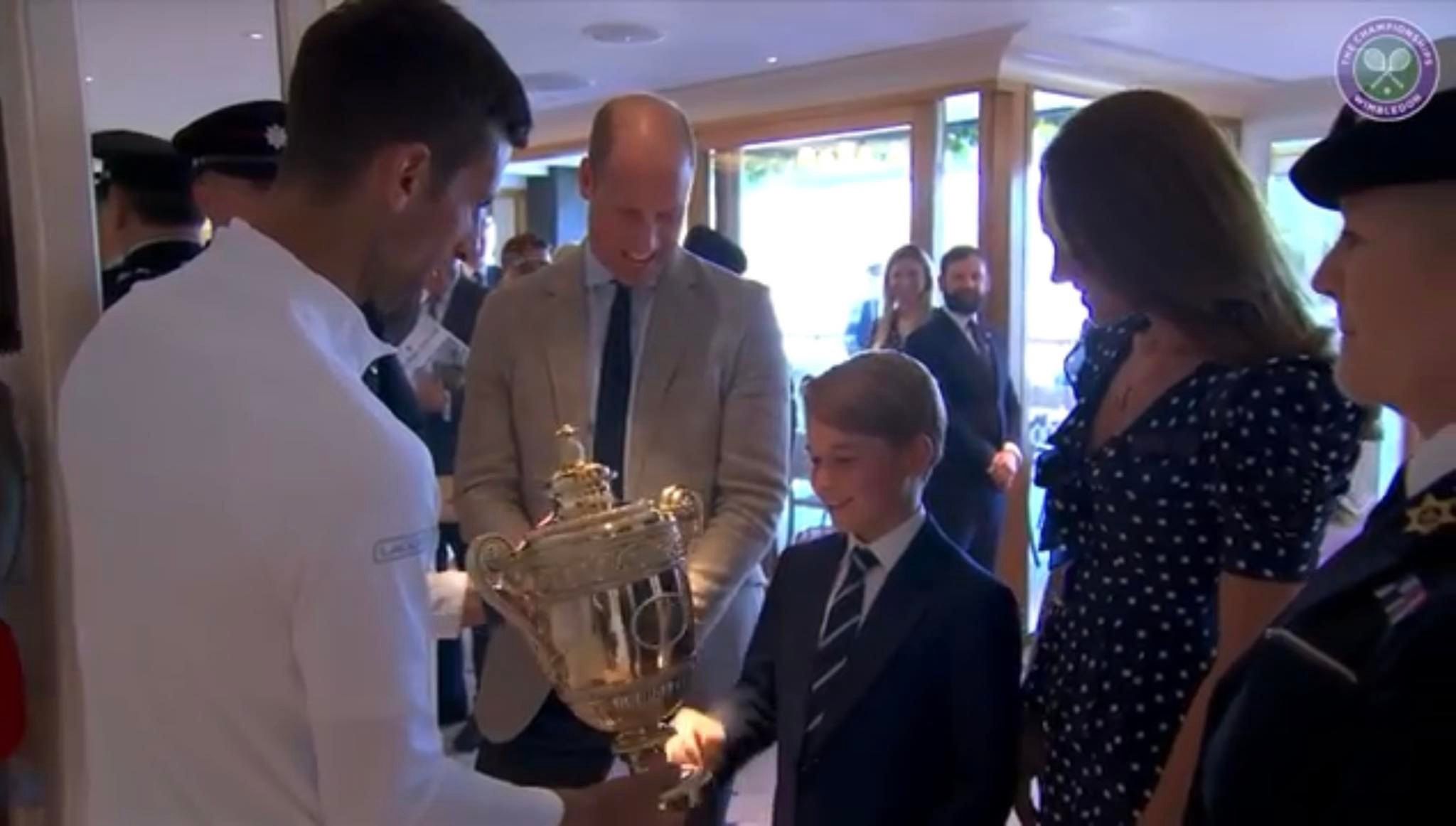 Książę George trzyma trofeum zwycięscy Novaka Djokovića