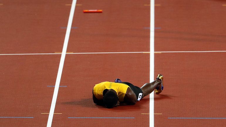 Usain Bolt leżący na bieżni Stadionu Olimpijskiego w Londynie