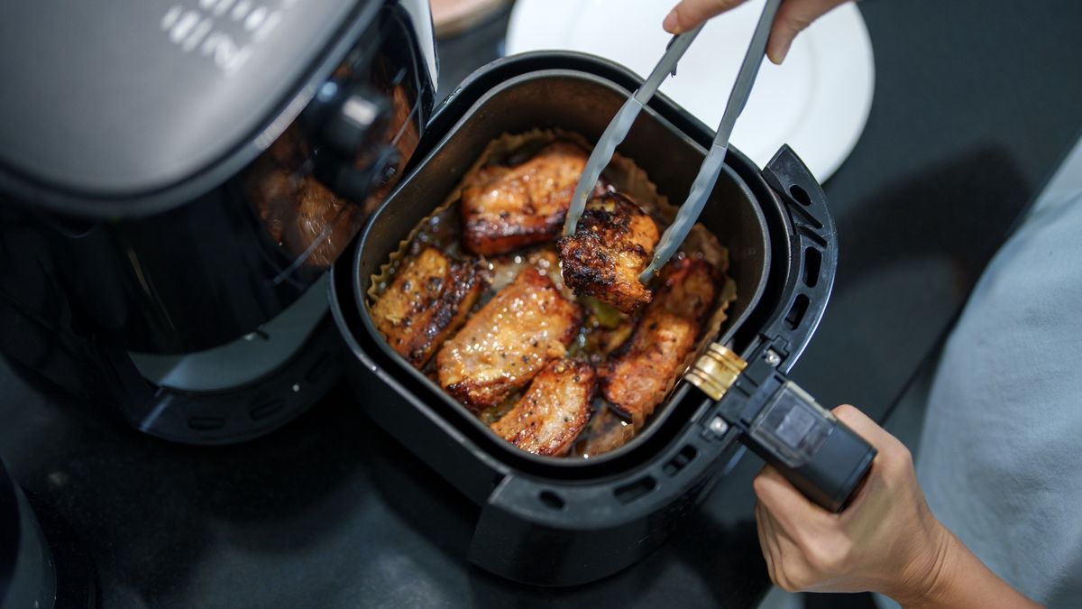Air-Fried Grilled Pork Belly in a Home Kitchen
Freshly grilled pork belly with a golden-brown, crispy exterior cooked in an air fryer. The sizzling meat is being picked up with tongs, highlighting a home-cooked meal with rich seasoning.
Thai Liang Lim