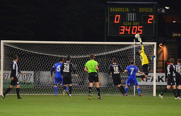 Marcin Cabaj musiał się natrudzić, by sparować strzał głową Marcina Krzywickiego. Fot. Jarosław Para, sandecja.com.pl