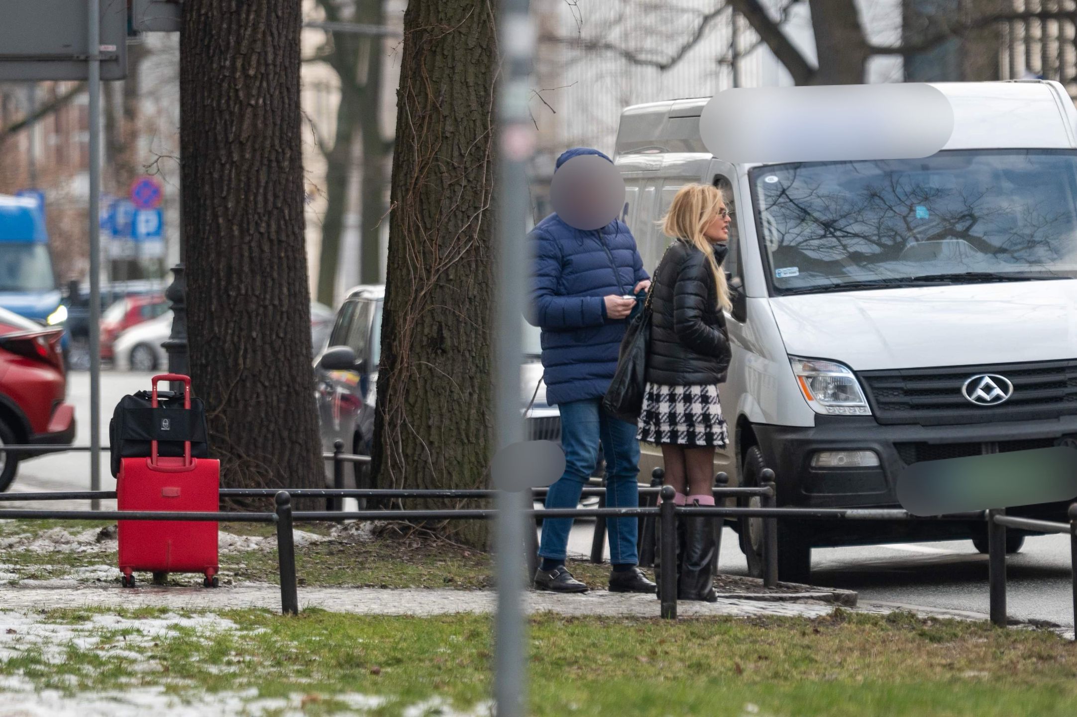 Monika Olejnik w krótkiej spódnicy czeka przy ulicy z walizkami