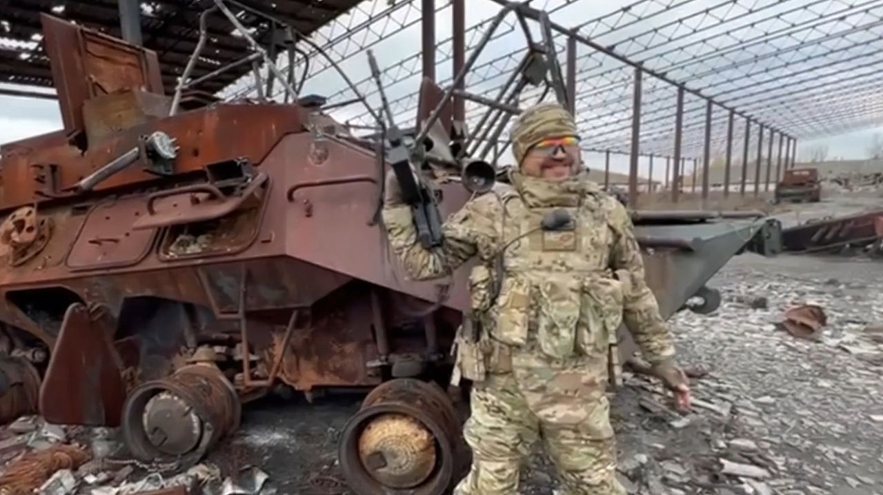 Rosyjski żołnierz na tle zniszczonego wozu R-149BMR