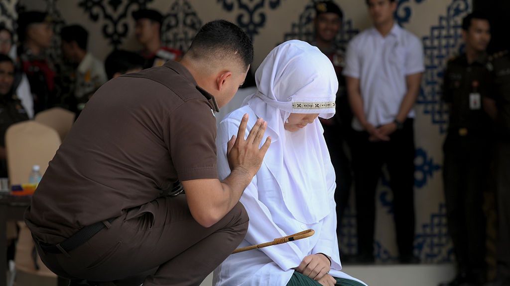 Kobieta podczas kary chłosty w Indonezji
