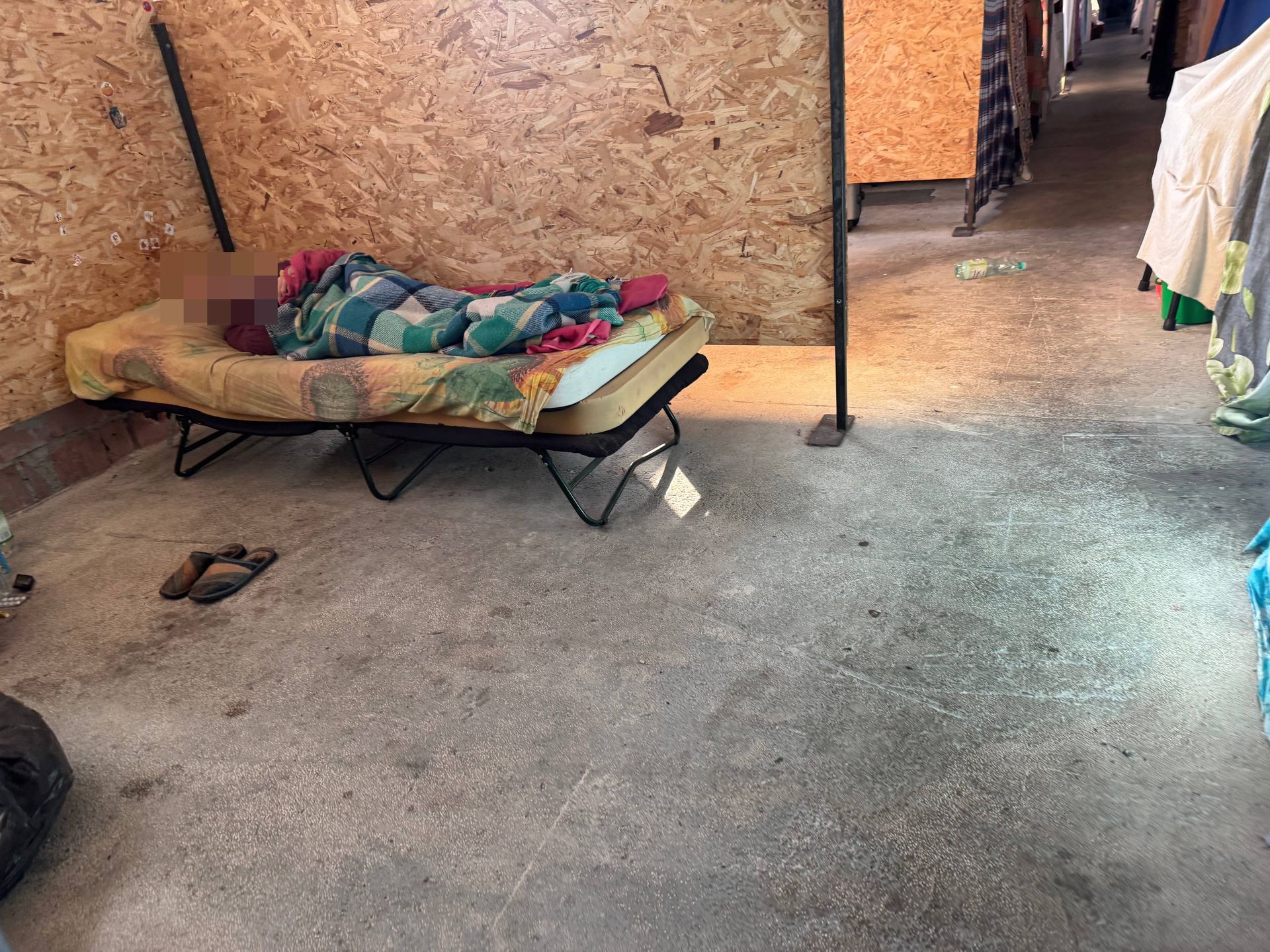 Mijam starszego mężczyznę, który śpi pomiędzy boksami