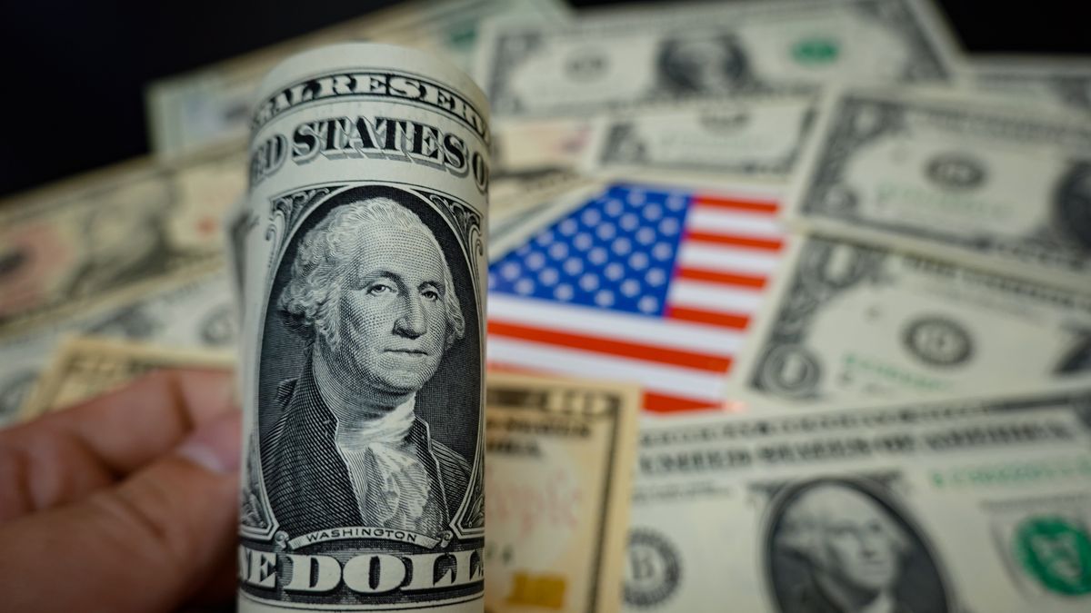 CHINA - 2024/09/19: In this photo illustration, some dollar banknotes are displayed on a table, along with an American flag. (Photo Illustration by Sheldon Cooper/SOPA Images/LightRocket via Getty Images)
