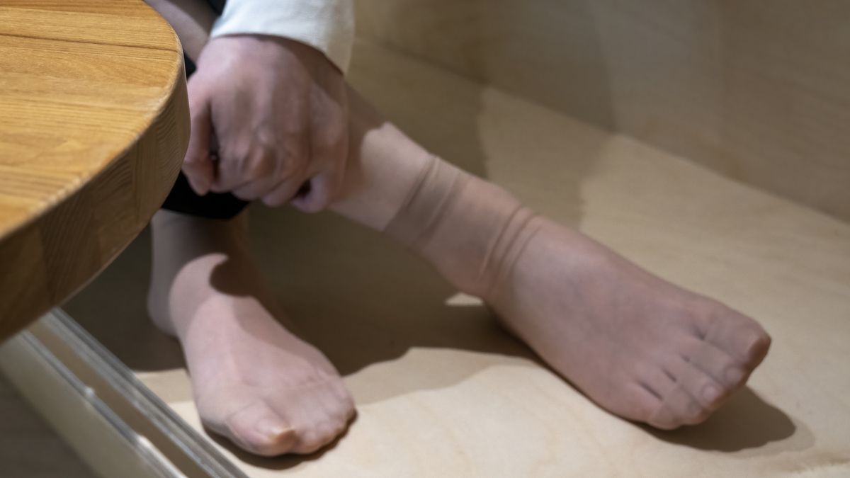 Woman holding legs sitting on the edge of the coffee tableWoman holding legs sitting on the edge of the coffee tablelingqi xie