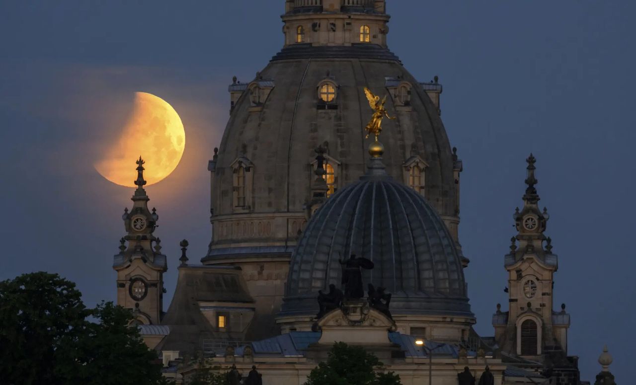Księżyc zachodzi w Dreźnie w Niemczech o poranku za kościołem Frauenkirche i kopułą Künstakademie z aniołem Famą