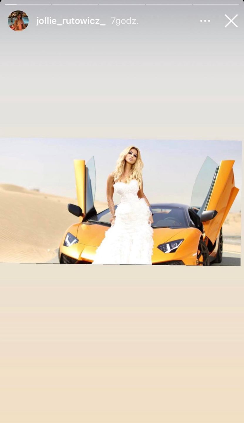 Jola Rutowicz w sukni ślubnej i z lamborghini za plecami 