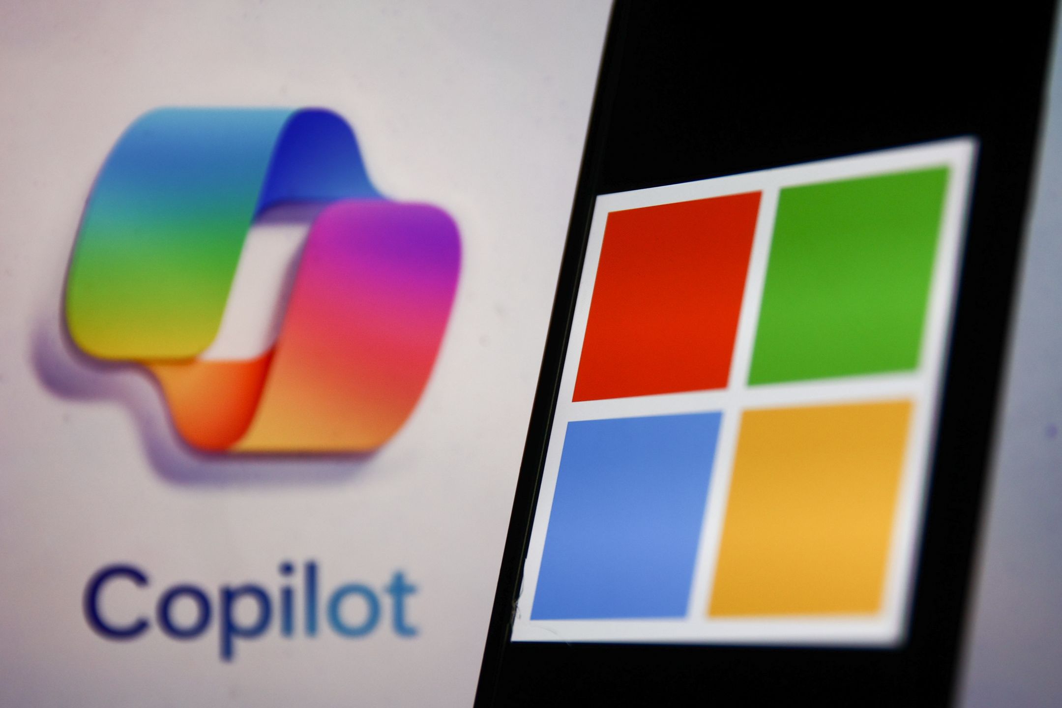 Copilot logo displayed on a laptop screen and Microsoft logo displayed on a phone screen are seen in this illustration photo taken in Krakow, Poland on October 30, 2023. (Photo by Jakub Porzycki/NurPhoto via Getty Images)