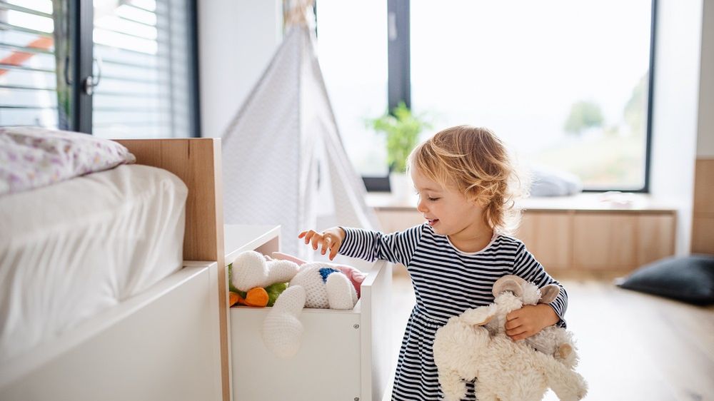 dziecko wkłada zabawki do szuflady, dziecko sprząta