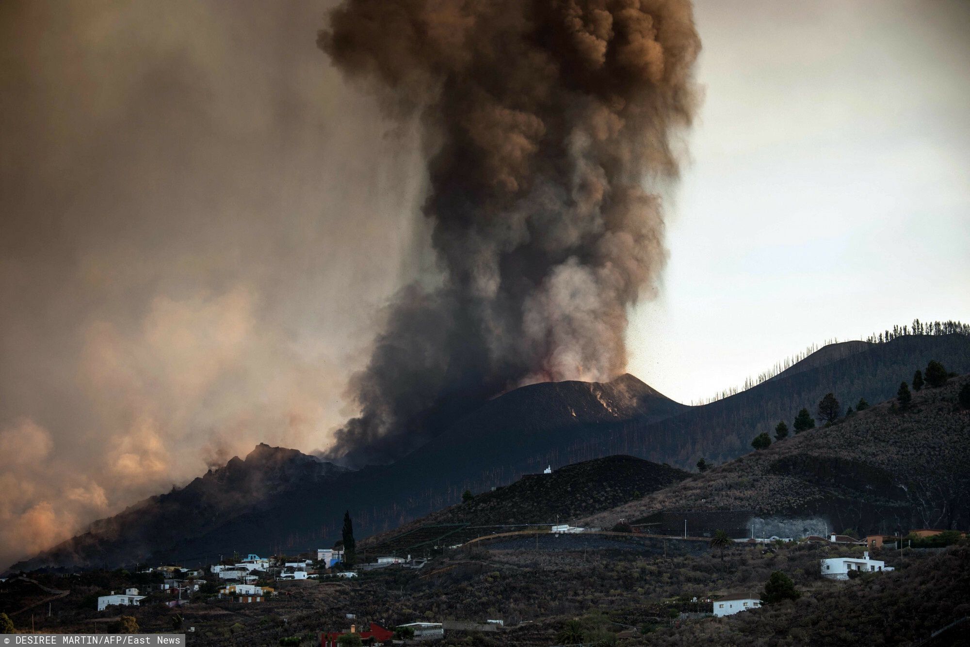 TemporaryThe Cumbre Vieja volcano is seen from Los Llanos de Aridane on the Canary island of La Palma in September 25, 2021. - La Palma airport, affected by the eruption of the Cumbre Vieja volcano, is inoperative due to the volcanic ash accumulation, AENA, the public body that manages Spanish airports, reported today. The Cumbre Vieja went on erupting on September 19, 2021 forcing the evacuation of more than 6,000 people and covering with lava more than 180 hectares (445 acres) of land. (Photo by DESIREE MARTIN / AFP)DESIREE MARTIN