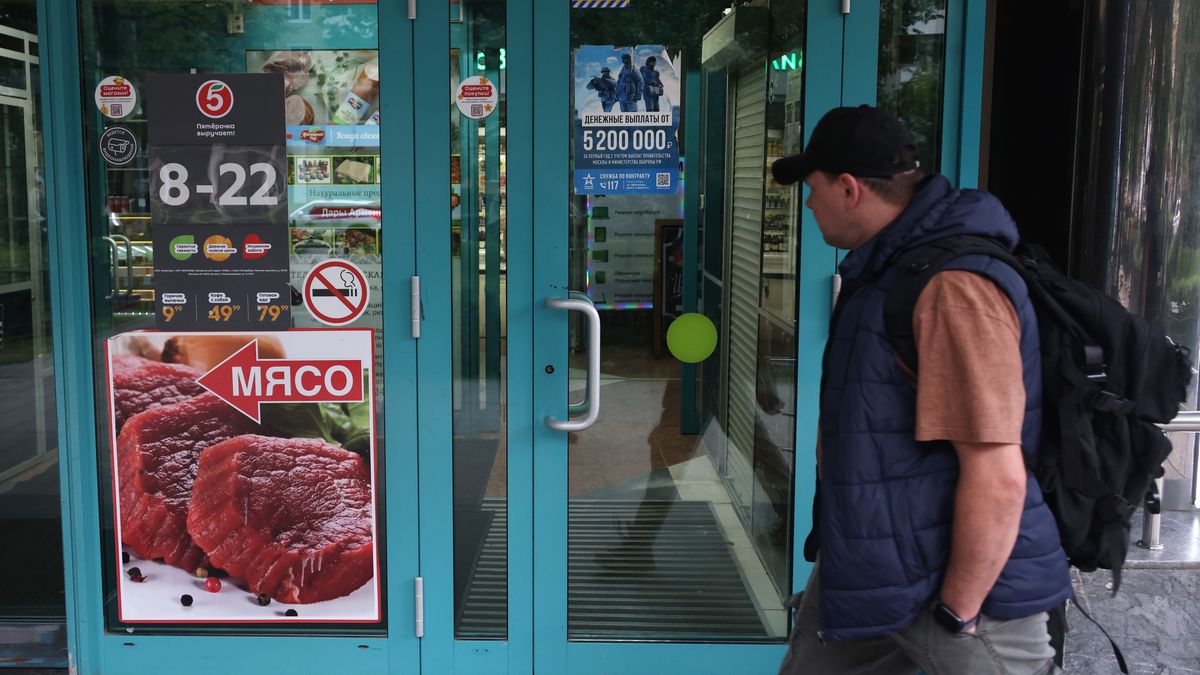 MOSCOW, RUSSIA - AUGUST 11  (RUSSIA OUT) A passerby looks at a banner promoting a contract service in Russian Armed Forces for participating in the military invasion of Ukraine installed at the entrance to the supermarket on August 11, 2025, in Moscow, Russia. The sign reads: "Payments from 5 200 000 rubles." (Photo by Contributor/Getty Images)