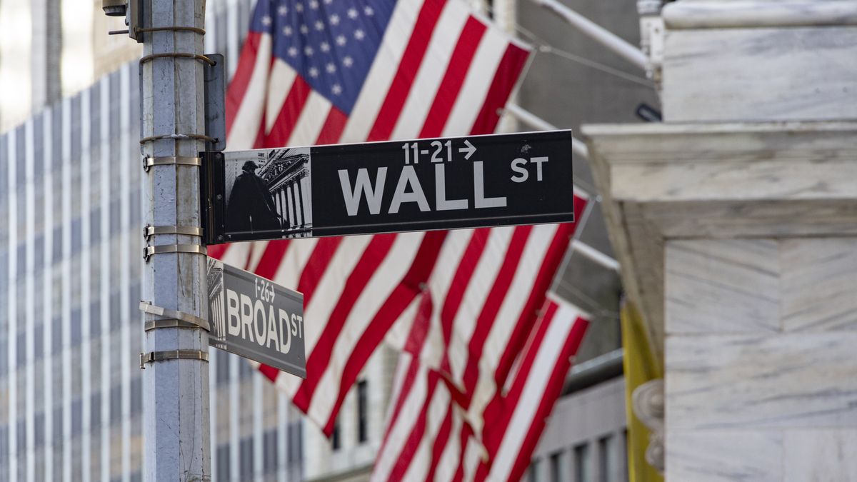 Wall Street sign inscription as seen with the American flag in the background on the road and buildings of Wall St, downtown in lower Manhattan as the area is a significant financial district for the American and the global economy, banking system and markets with the headquarters of companies and financial institutions located there like the New York Stock Exchange NYSE. New York City, USA on November 12, 2024 (Photo by Nicolas Economou/NurPhoto via Getty Images)
