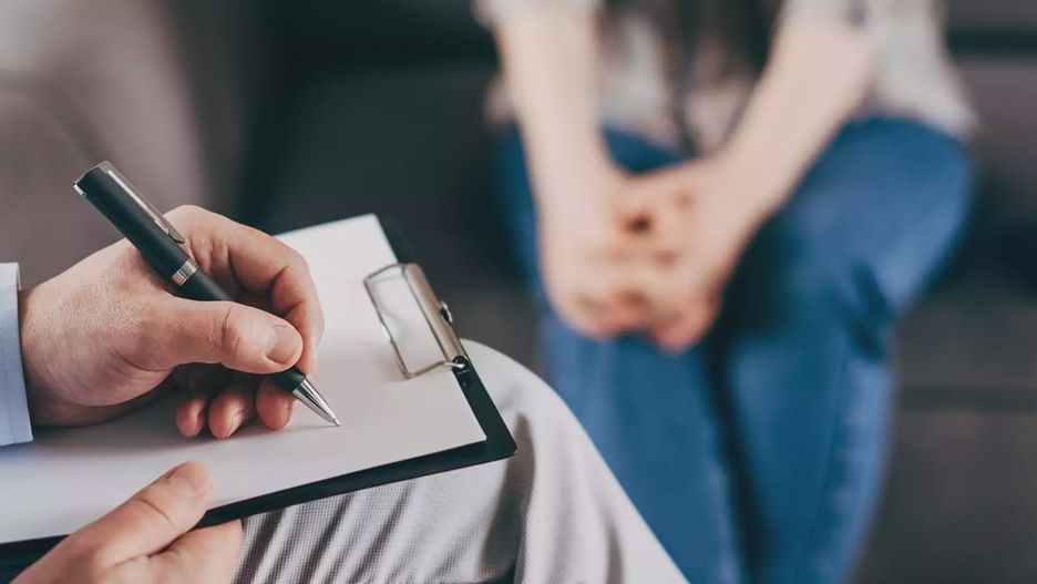 The psychologist makes a social survey of the reference group. A professional is talking to a client. Informal communication at the interview, business consultant writes notes in a notebook.