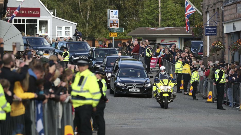 Trumna z cia?em kr�lowej wyruszy?a z Balmoral do EdynburgaMembers of the public line the streets in Ballater, Scotland, as the hearse carrying the coffin of Queen Elizabeth II passes through as it makes its journey to Edinburgh from Balmoral in Scotland, Sunday, Sept. 11, 2022. The Queen's coffin will be transported Sunday on a journey from Balmoral to the Palace of Holyroodhouse in Edinburgh, where it will lie at rest before being moved to London later in the week. (AP Photo/Scott Heppell)AP