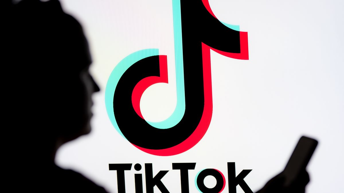 POLAND - 2025/03/07: In this photo illustration, a woman seen looking at a smartphone with a TikTok logo displayed in the background. (Photo Illustration by Mateusz Slodkowski/SOPA Images/LightRocket via Getty Images)