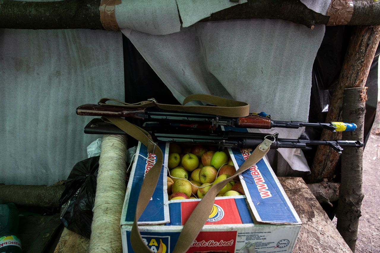 Broń leżąca na jabłkach w polowej kuchni.