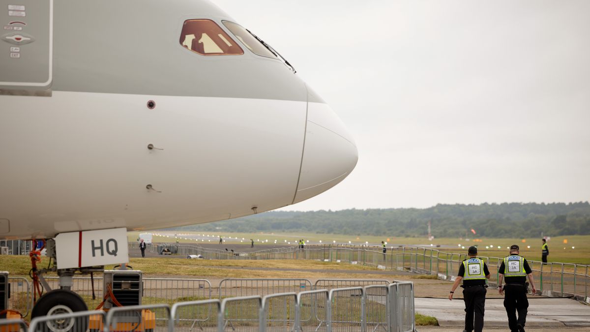 Police officers pass a Boeing 787 Dreamliner, operated by Qatar Airways, during the opening day of the Farnborough International Airshow in Farnborough, UK, on Monday, July 22, 2024. The aviation summit is typically a platform for planemakers to rack up multibillion-dollar deals. Photographer: Jason Alden/Bloomberg via Getty Images