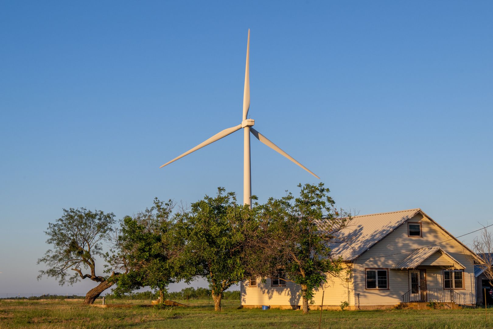 NOLAN, TEXAS - JUNE 28: A wind turbine behind a house at dawn on June 28, 2024 in Nolan, Texas.  (Photo by Brandon Bell/Getty Images)
