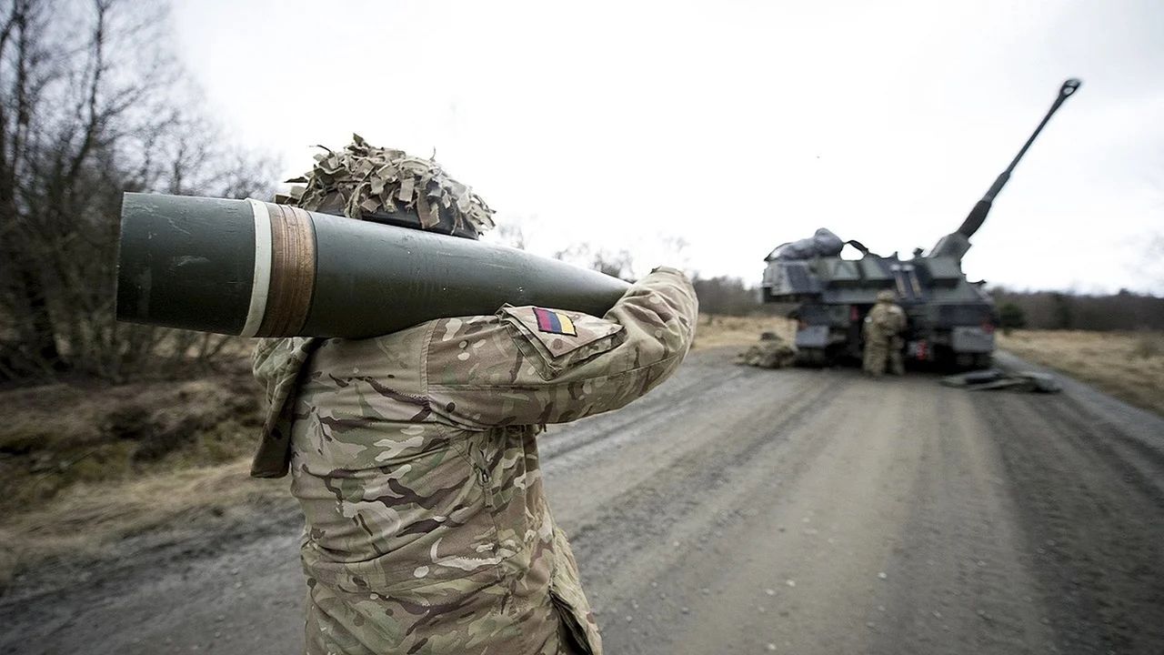 Pocisk kalibru 155 mm. Ładunek miotający ładowany jest oddzielnie. W tle brytyjska haubica AS90